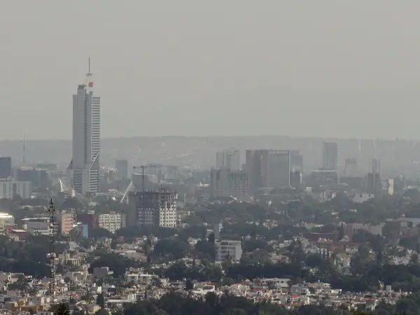 Vista panorámica de Guadalajara con edificios altos y una neblina que afecta la calidad del aire.